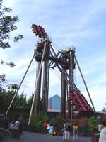 Slammer, a thrill ride at Thorpe Park in England. This ride carries up to 48 people in 2 groups of 24; each group is seated at one end of a long arm, with the groups facing each other. When in operation, the arm pivots about the center, so that one group is lifted up and over the pivot point, while the other group is dropped below it. The arm makes several complete rotations, inverting the riders, then stops and rotates in the opposite direction so that both groups experience a "swatting" motion as the arm carries them face-down towards the ground.