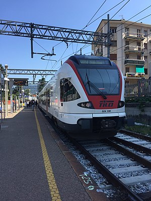 White-and-red train on tracks next to platform