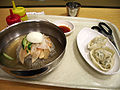 Mul naengmyeon or Pyongyang naengmyeon (cold buckwheat noodle soup) and mandu (stuffed dumplings).
