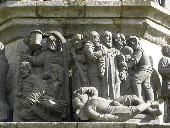 Jesus' arrest.This sculpture on the Plougonven calvary's south side depicts Jesus' arrest. On the left is Judas Iscariot holding a purse and below him an apostle sleeping, whilst a second, St Peter is also asleep his hand on his sword. Then is Judas embracing Jesus to identify him. He is held by two guards. St Peter now puts his sword back in its sheath having struck Malchus who lies on the floor