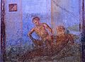 A female is sitting on a male's lap, lowering herself on his penis. Wall painting from Pompeii, 1st Century