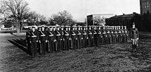Group photograph of members of a military drill team standing at attention