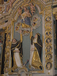 In the centre of the altarpiece's lower section, the Virgin Mary hands the rosary to Saint Dominic and Catherine of Sienna