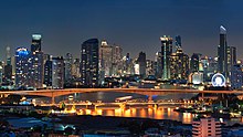 View of the Krung Thep Bridge at night with many skyscrapers in the background