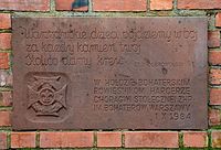 The plaque behind the statue