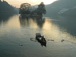A Bhimtal lake dweller with his boat in Nainital district, Uttarakhand, India