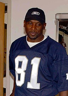 Tim Brown from the waist up in an unidentified jersey and black hat.
