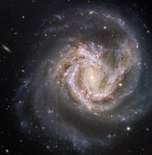 Spiral galaxy Messier 61 is aligned face-on towards Earth.[24]
