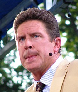 A man with a microphone next to his left ear