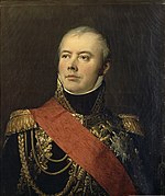 Portrait of a slightly balding man taking an heroic pose with his head tilted back. He wears a dark blue marshal's uniform with elaborate gold braid and a large red sash across his right shoulder.
