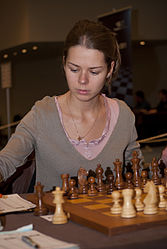 Kosintseva writing down a move at chess board