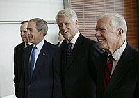 Carter (right), walks with, from left, George H. W. Bush, George W. Bush, and Bill Clinton during the dedication of the William J. Clinton Presidential Center and Park in Little Rock, Arkansas on November 18, 2004
