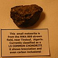 Meteorite is from the NWA 869 strewn field, near Tindouf, Algeria. Classified as a L5 COMMON CHONDRITE it shows brecciation and carbon inclusions.[46]