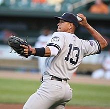 A man in a gray baseball uniform preparing to throw a ball