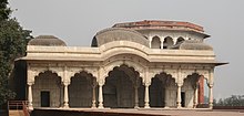 Low, white building with ornate pillars and arches