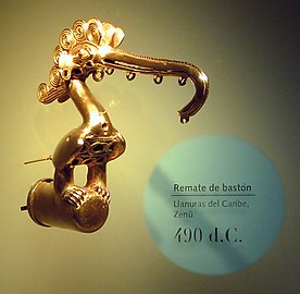 A lowland Zenú cast-gold bird ornament that served as a staff head. dated 490 CE. This culture used alloys with a high gold content. The crest of the bird consists of the typical Zenú semi-filigree. Regular filigree is braided wire. but the Zenú cast theirs.