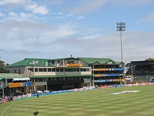 A view of a cricket field focusing towards the pavilion