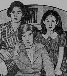 Photograph of two somber-faced young girls on either side of their mother