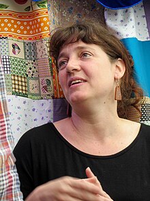 Nadia Fink standing in front of a quilt