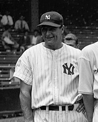 A smiling man in a dark cap and white pinstriped baseball uniform with an interlocked "N" and "Y" on the left breast.
