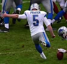 Matt Prater in his Lions uniform. He is mid-field goal attempt, with his leg back about to kick the ball.