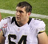 A light-skinned man wearing a football jersey