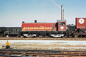 A red locomotive in a freight yard