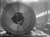 A female worker cleans the breech threads of a 15-inch gun from inside the barrel in the Coventry Ordnance Works during WWI