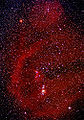 Long exposure of Orion with red clouds of ionized hydrogen (H-alpha). The big bow on the left is Barnard's Loop.