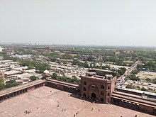 Image shows Red Fort's long walls including the gates as seen from Jama Masjid's tower. The walls can be seen in the background extending a couple of thousand meters.