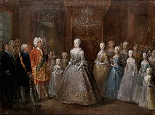 A throne room with a middle-aged lady in a silver dress standing in the middle, facin a man in a gilded red coat. Between them is a little girl in a light blue dress and a boy. Behind the lady stand five young girls, descending in height towards the edge of the canvas. Many courtiers are standing in the bacgkround.