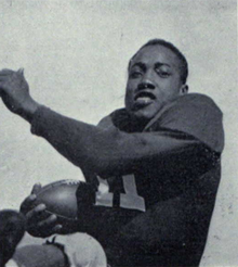 Black and white photo of Withers rushing the football in uniform