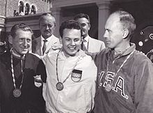 Black and white photograph of three men, wearing Olympic medals.