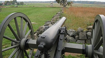Photo closeup shows a black cannon pointing away from the viewer.