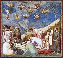 Square fresco. In a shallow space like a stage set, lifelike figures gather around the dead body of Jesus. All are mourning. Mary Magdalene weeps over his feet. A male disciple throws out his arms in despair. Joseph of Arimethea holds the shroud. In Heaven, small angels are shrieking and tearing their hair.