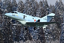 An U-125A aircraft taking off in the winter.