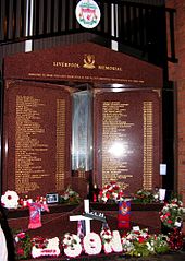 Hillsborough Memorial, which is engraved with the names of the 97 people who died in the Hillsborough disaster. Flowers are below the memorial.