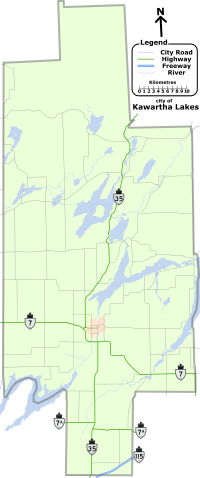 "A map of the entire City of Kawartha Lakes, outlined by a grey line. The lakes, rivers, and roads of the region are shown. Lakes and rivers are dotted across the region and represented by blue shapes and lines. Kawartha Lakes is shaped like a cross which has been stretched vertically, and is approximately one quarter as wide as it is tall. For identification purposes, the remaining items are described in reference to the horizontal and vertical bar of the cross. Provincial highways, labelled, cross the map in several locations: Highway 35 bisects the entire map, travelling vertically from the bottom-centre to the upper-right along the vertical bar. Highway 7 crosses horizontally just below the mid-point from the left; After crossing Highway 35, it proceeds at an angle to the bottom right corner of the horizontal bar. Highway 7A is a straight and horizontal, bisecting the map below the horizontal arm of the cross. Highway 115, shown as two lines as it is a divided freeway, occupies a small space near the bottom-right corner of the vertical bar, crossing it at a forty-five degree angle up and to the right. The remaining black lines represent the numbered city roads."