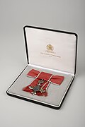 Photograph of the MBE medal awarded to Madeleine Sharp in 2002 in its presentation case.