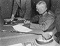 Image 11 German Instrument of Surrender Photograph credit: Lt. Moore; restored by Adam Cuerden The German Instrument of Surrender was the legal document that effected the termination of the Nazi regime and ended World War II in Europe. A July 1944 draft version had also included the surrender of the German government, but this was changed due to concern that there might be no functional German government that could surrender; instead, the document stated that it could be "superseded by any general instrument of surrender imposed by, or on behalf of the United Nations", which was done the next month. This photograph shows Field Marshal Wilhelm Keitel signing the German Instrument of Surrender in Berlin. The first surrender document was signed on 7 May 1945 in Reims by General Alfred Jodl, but this version was not recognized by the Soviet High Command and a revised version was required. Prepared in three languages on 8 May, it was not ready for signing in Berlin until after midnight; consequently, the physical signing was delayed until nearly 1:00 a.m. on 9 May, and backdated to 8 May to be consistent with the Reims agreement and public announcements of the surrender already made by Western leaders.