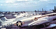 A lineup of silver piston-engined fighters, the one in the front of the line with clearly visible U.S. Air Force insignia and 'PQ-332" coding on the rear fuselage