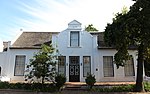 This house displays a harmonious mixture of Cape Dutch and Georgian characteristics. The oldest portion presumably dates from the beginning of the 18th century. The property forms an essential architectural and aesthetic keystone in the historic core of Stellenbosch.