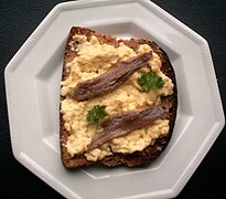 Scotch woodcock, scrambled eggs on toast garnished with anchovy fillets and parsley