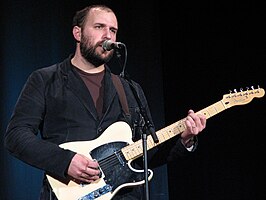 Bazan onstage with a guitar and microphone