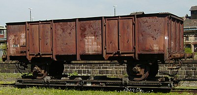 Twin-axled UIC Type 1 open wagon, used as an ash wagon, on a transporter wagon in Zittau