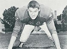 Alex Karras in a jersey and on his hands and toes, as if about to rush a passer.