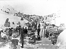 Klondikers and their supplies at US-Canadian border line on Chilkoot Pass, 1898
