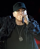 Side profile of a man wearing black hat, black coat and black shirt