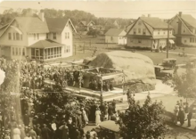 A photograph of a ceremony during which the memorial plaque was unveiled on the Glen Rock during 1921. In the foreground are about one hundred citizens, while there are several houses in the background.