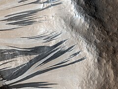 One theory is dark sand flowed down the slopes of Acheron Fossae. However, they lighten in color over time.[3]